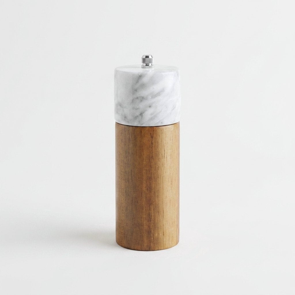 White marble-topped acacia wood top grinder mill with a silver knob on a white studio background