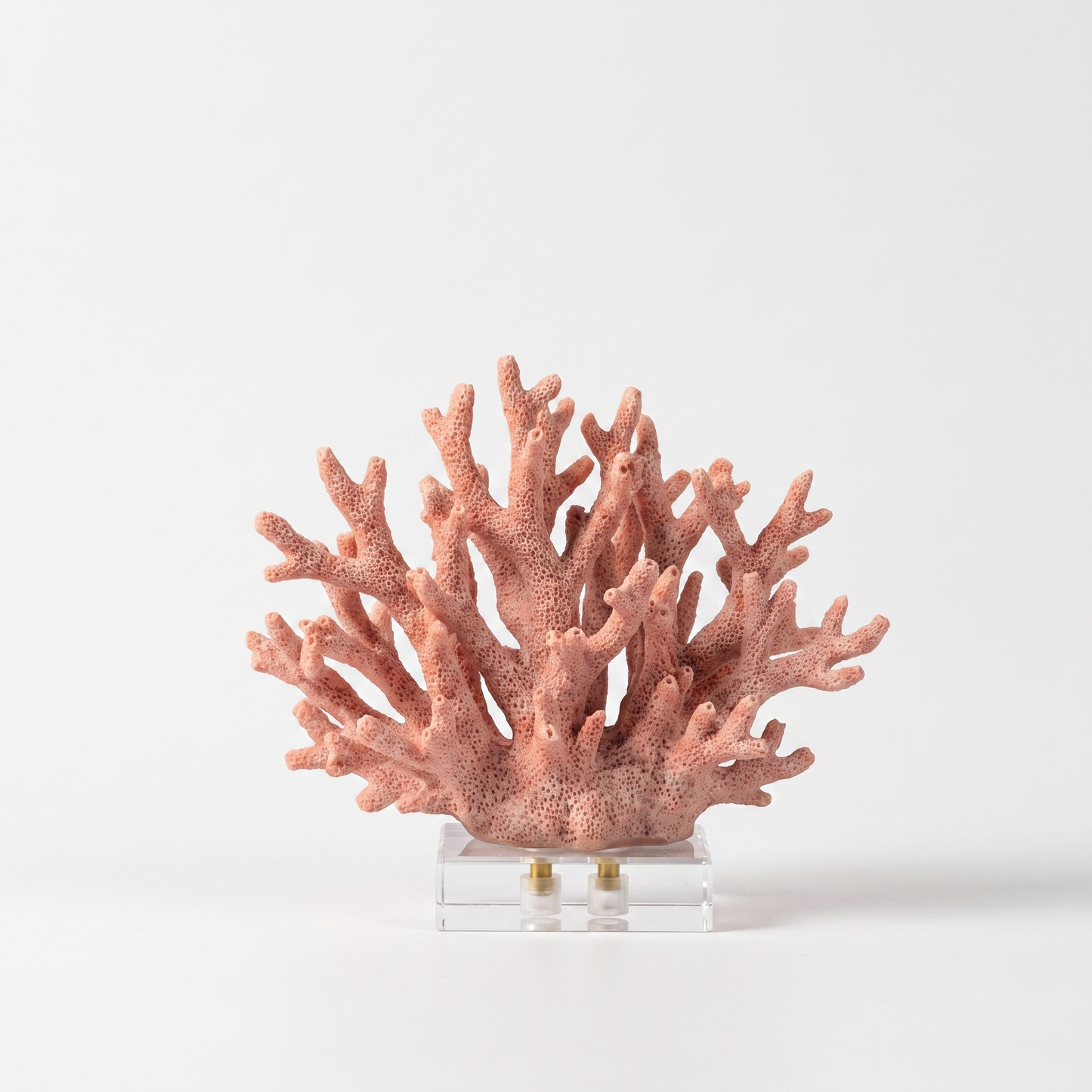Pink marble coral sculpture on a white marble base, off-white background