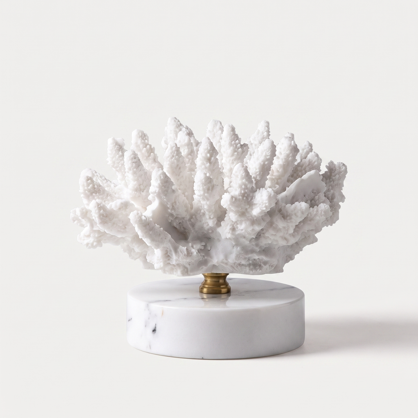 White brain-form marble coral sculpture on a marble base, off-white background