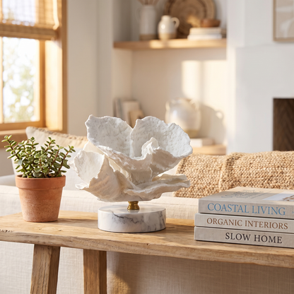 White marble coral sculpture on a wood console with dried pampas grass