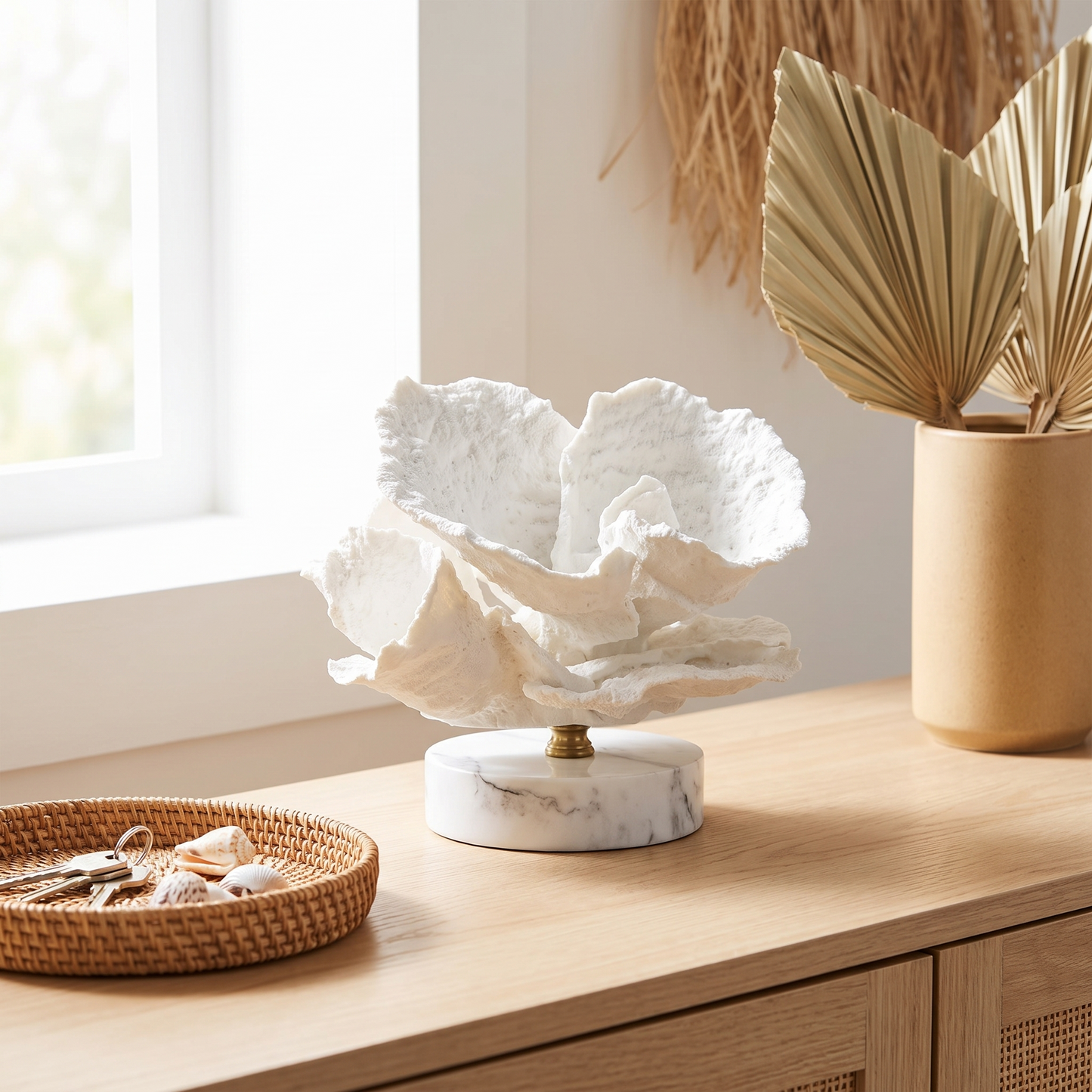 White marble coral sculpture on a console table beside books