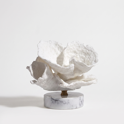 White scroll-form marble coral sculpture on a marble base, off-white background