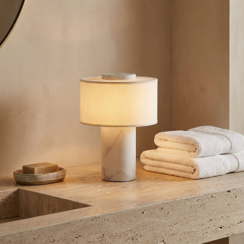Table lamp on a bathroom counter with towels and soap