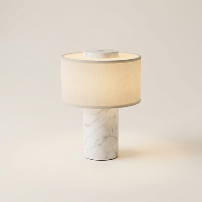 Table lamp with marble base and beige shade on a light background