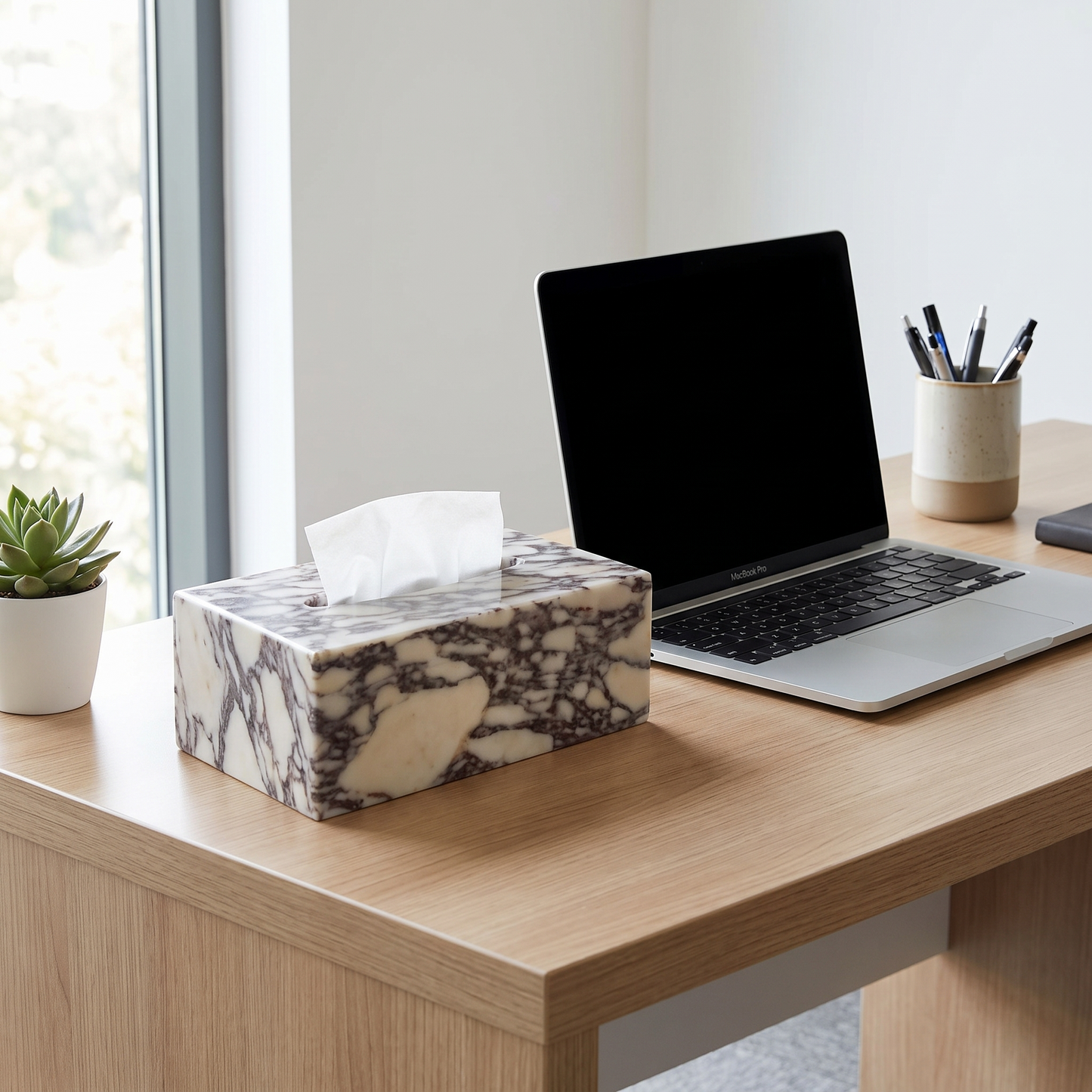 Calacatta marble tissue box cover on a desk beside a laptop
