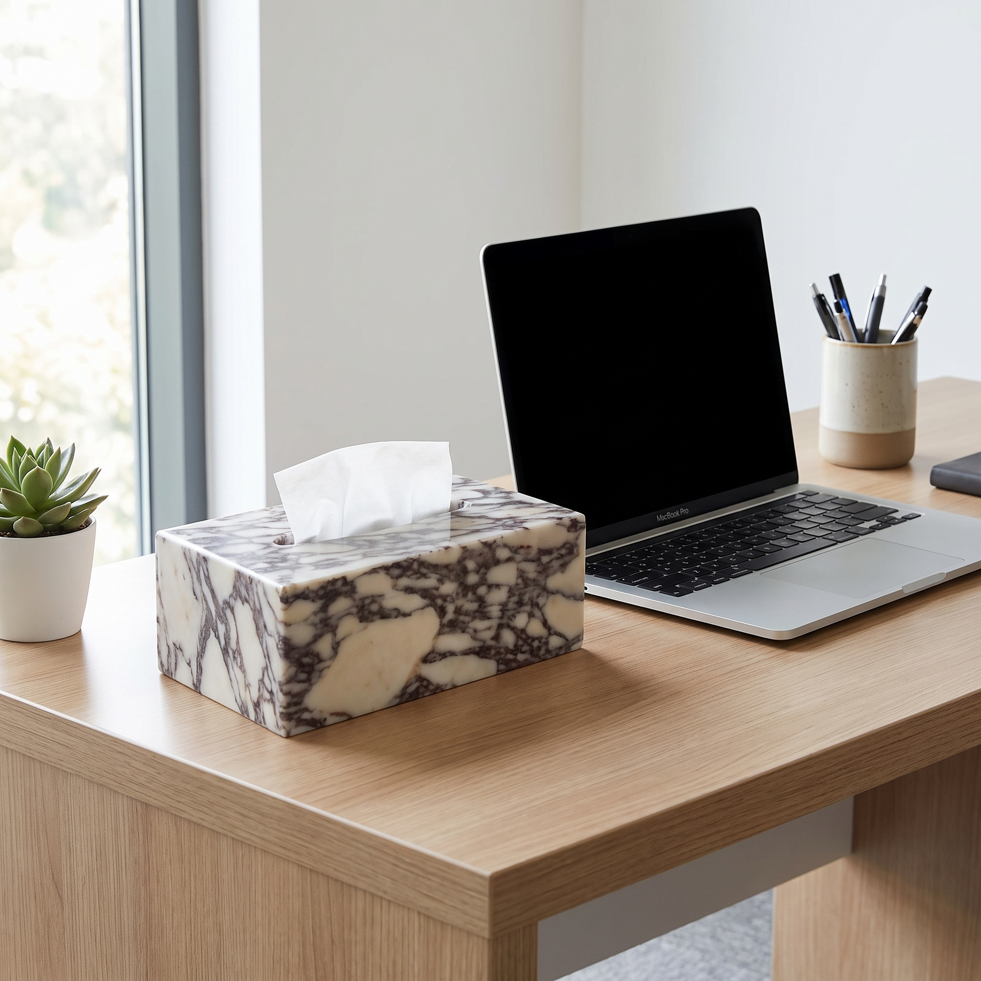Calacatta marble tissue box cover on a desk beside a laptop