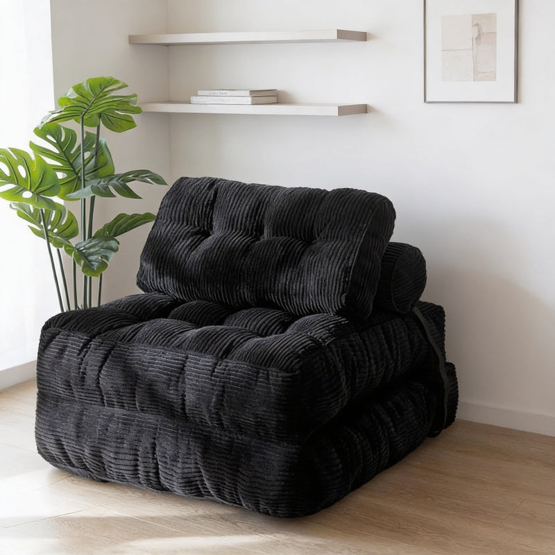 Black textured armchair in a room with a plant and shelves.