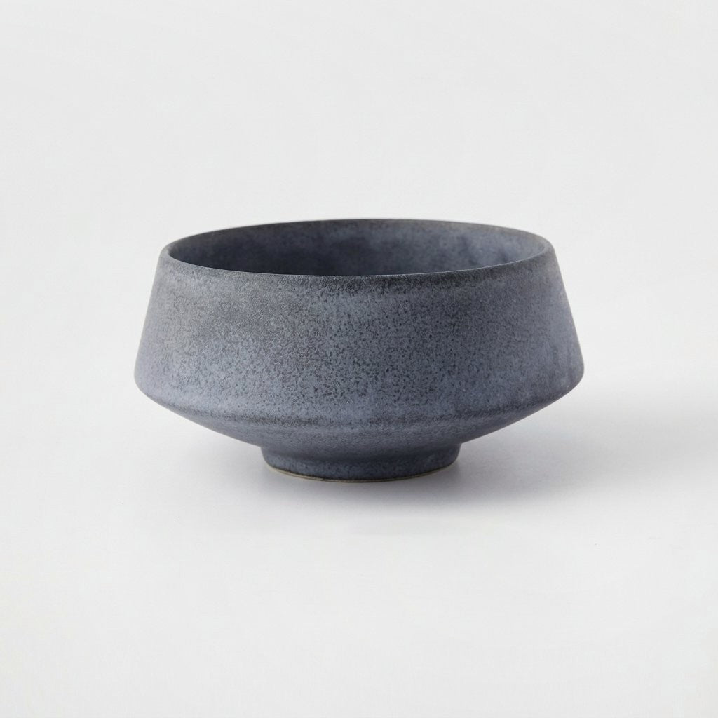 Large matte speckled blue-gray stoneware bowl on a light grey background