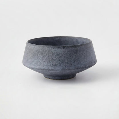 Large matte speckled blue-gray stoneware bowl on a light grey background