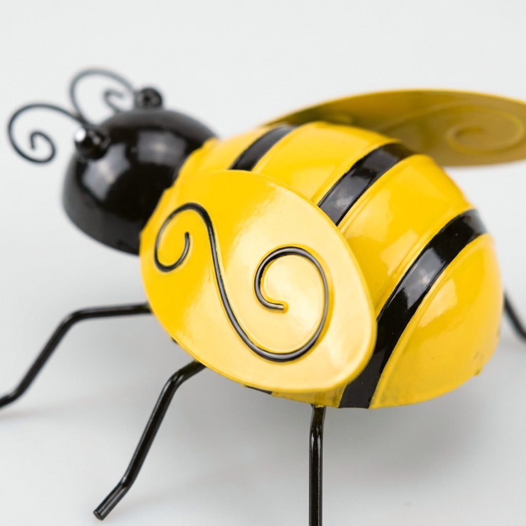 Close-up of painted metal bee showing wing detail and wire antennae