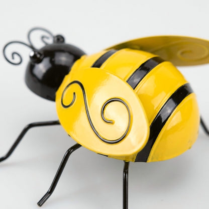 Close-up of painted metal bee showing wing detail and wire antennae