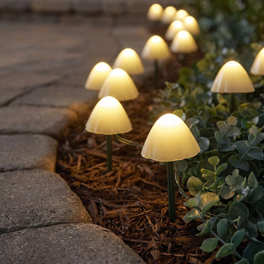 Mushroom-shaped garden lights along a stone pathway with plants.