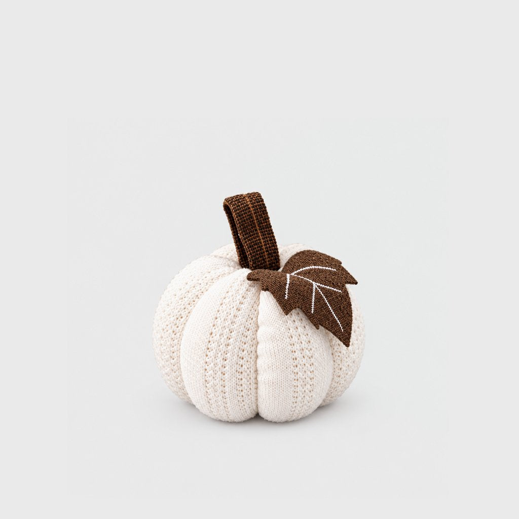 Single cream mini knit pumpkin with a brown stem and brown felt leaf on a plain light backdrop