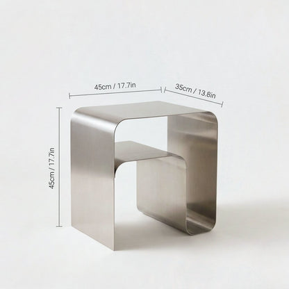 Brushed stainless steel arch side table with two tiers, labeled 45cm / 17.7in wide, 35cm / 13.8in deep and 45cm / 17.7in high on a plain light backdrop