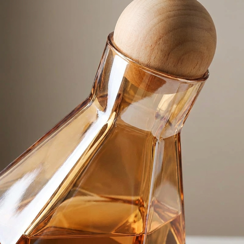Close-up of modern faceted glass decanter with wood stopper