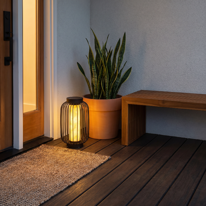 Modern outdoor solar lantern on deck beside potted plant at dusk
