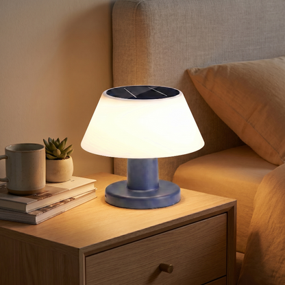 Modern portable solar table lamp on bedside table beside books