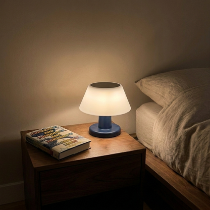 Modern portable solar table lamp on bedside table in softly lit bedroom