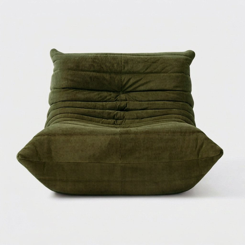 Forest green corduroy tufted lounge chair seen from the front on a light studio background
