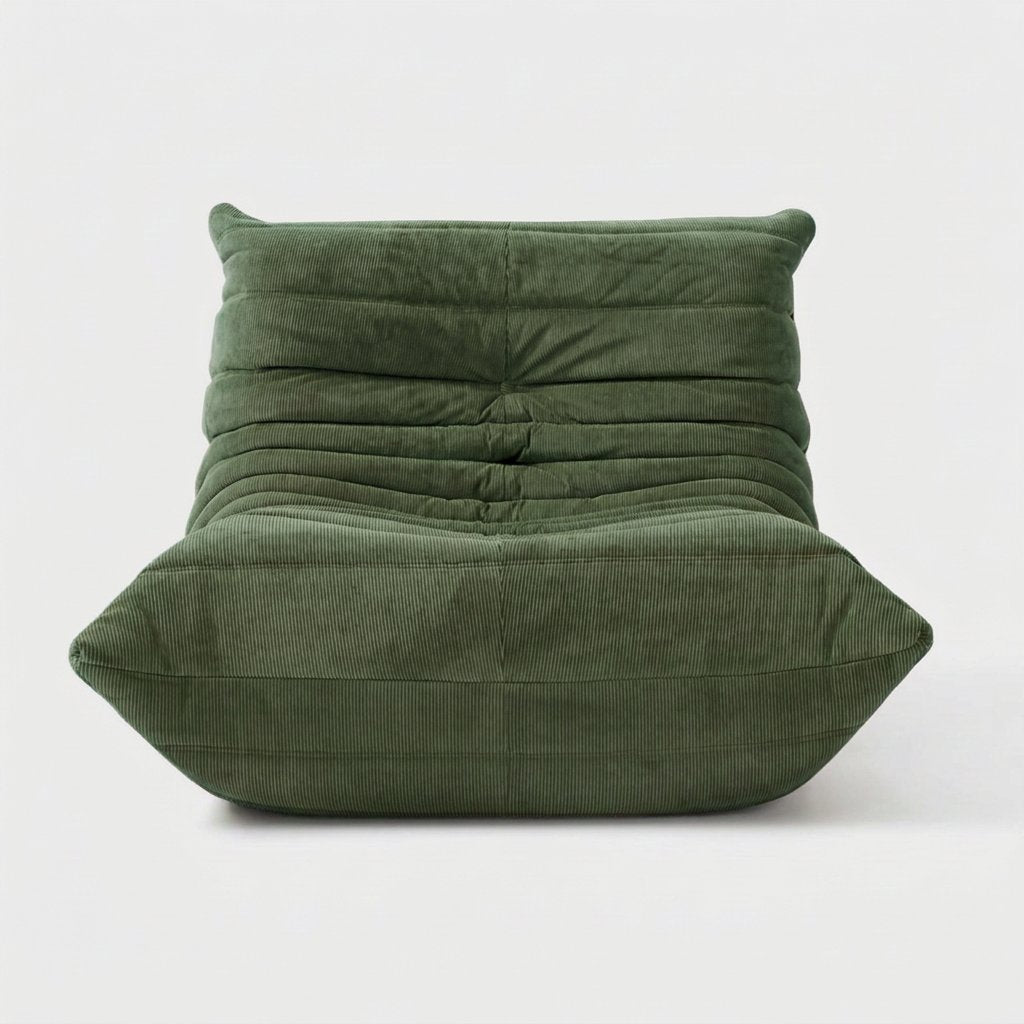 Sage green corduroy tufted lounge chair seen from the front on a light studio background