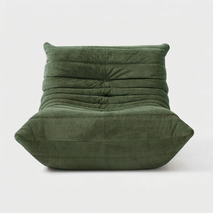 Sage green corduroy tufted lounge chair seen from the front on a light studio background