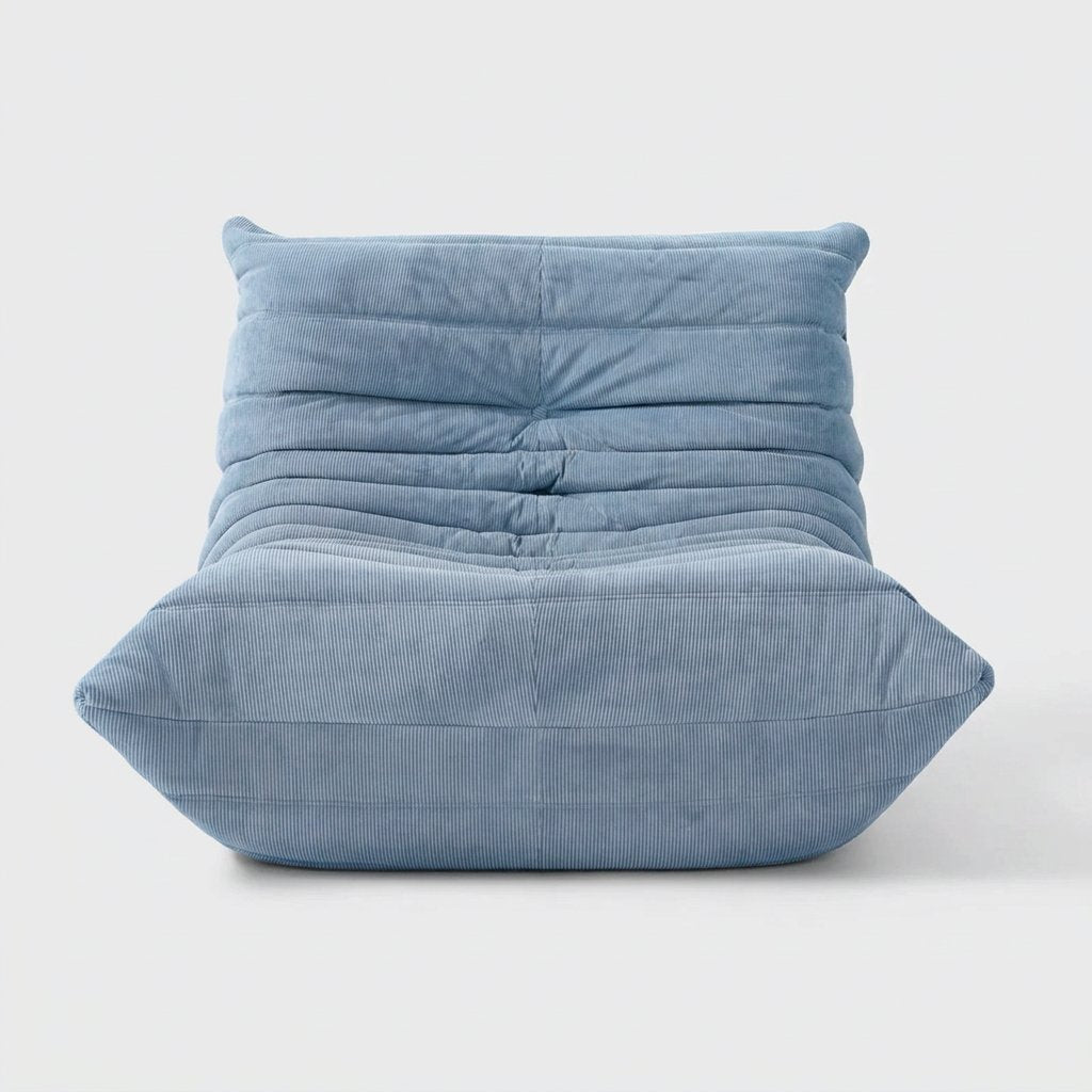 Light blue corduroy tufted lounge chair seen from the front on a light studio background