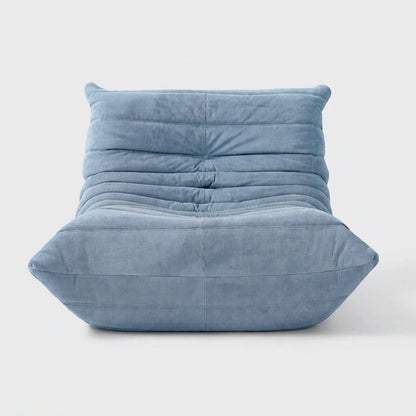 Light blue corduroy tufted lounge chair seen from the front on a light studio background