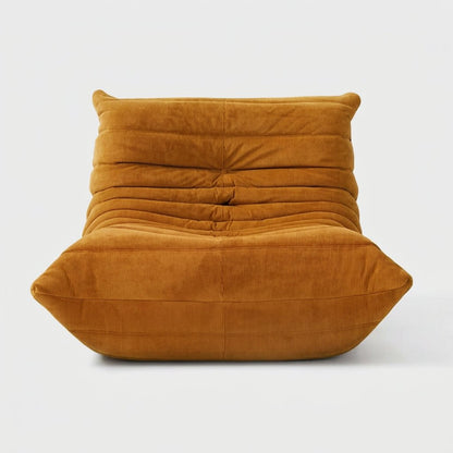 Mustard corduroy tufted lounge chair seen from the front on a light studio background