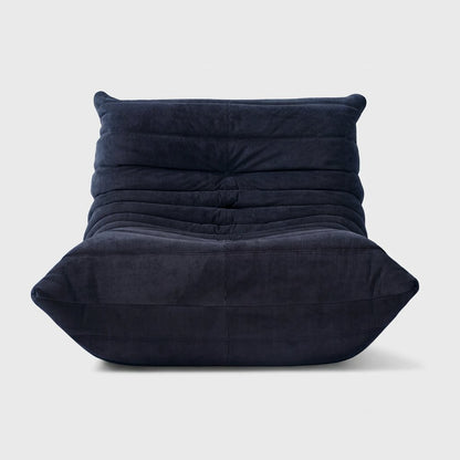 Navy corduroy tufted lounge chair seen from the front on a light studio background