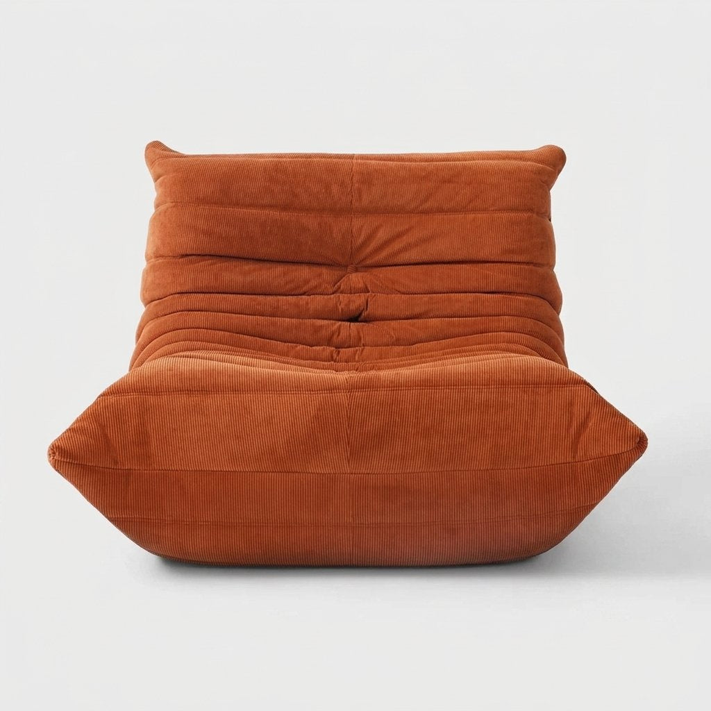 Burnt orange corduroy tufted lounge chair seen from the front on a light studio background