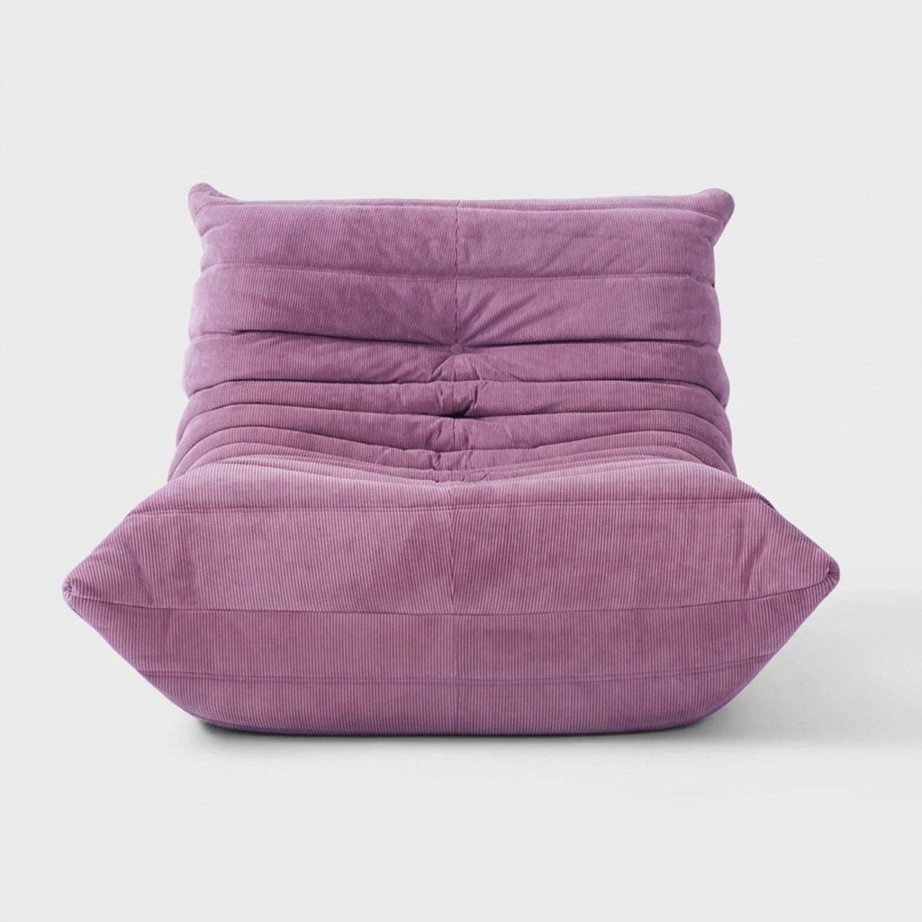 Lilac purple corduroy tufted lounge chair seen from the front on a light studio background