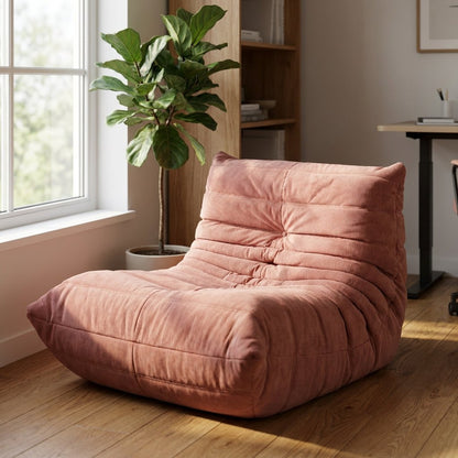 Dusty pink corduroy tufted lounge chair in a bright home office with a fiddle-leaf fig and bookshelf