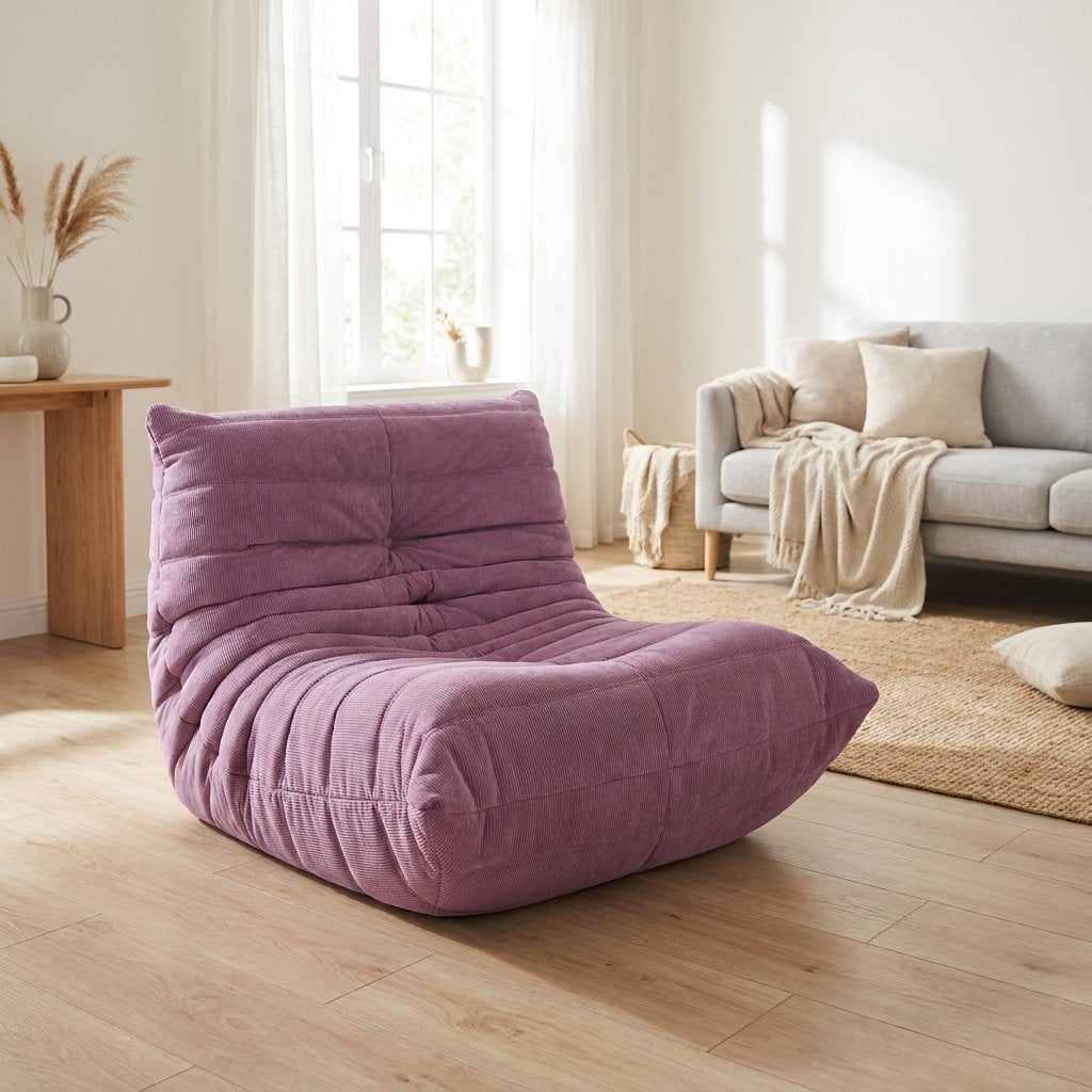 Dusty purple corduroy tufted lounge chair in a living room with a gray sofa and round jute rug