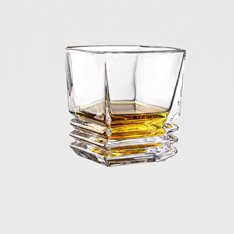Clear glass with whiskey on a light gray background