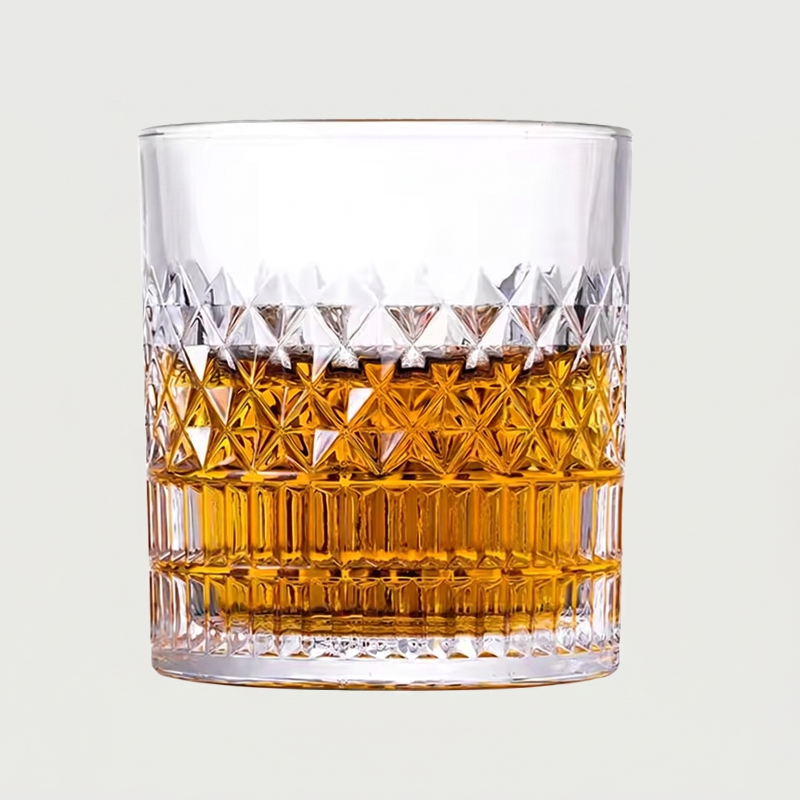 Glass filled with amber liquid on a light gray background