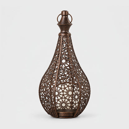 Bronze cutwork metal lantern with a pointed top and ring handle on a plain light background