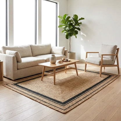 Natural jute hand-woven rug with black border in a living room, Kiyo Home
