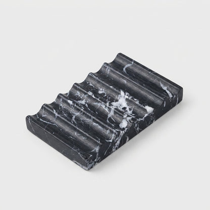 Black marble Natural Marble Soap Dish with white veining, ridged draining grooves, hero shot on a clean off-white background