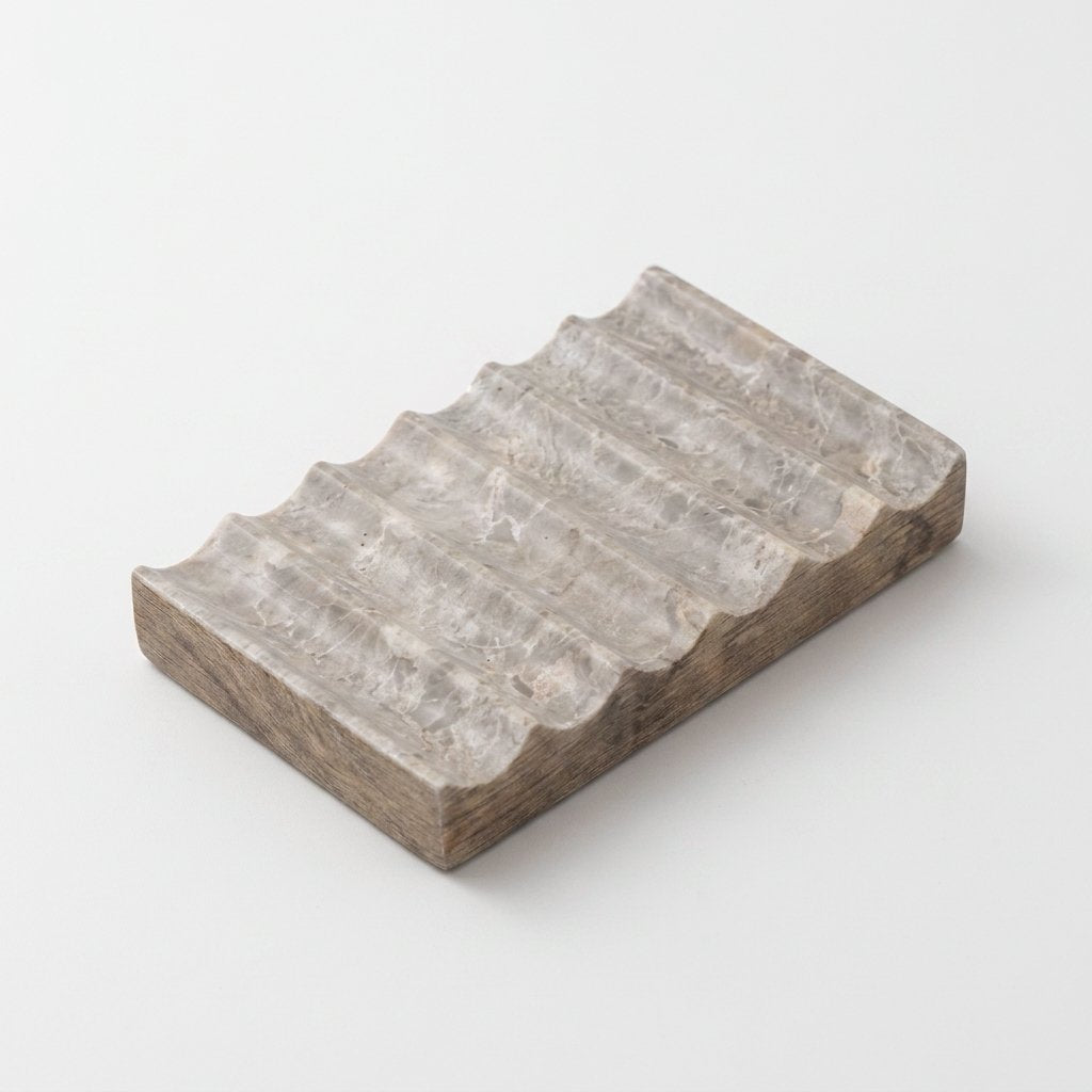 Natural tan marble Natural Marble Soap Dish with driftwood-like grey-brown tones, ridged draining grooves, hero shot on a clean off-white background