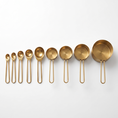 9-Piece Gold Stainless Steel Measuring Set with 5 spoons and 4 cups arranged on a clean off-white background