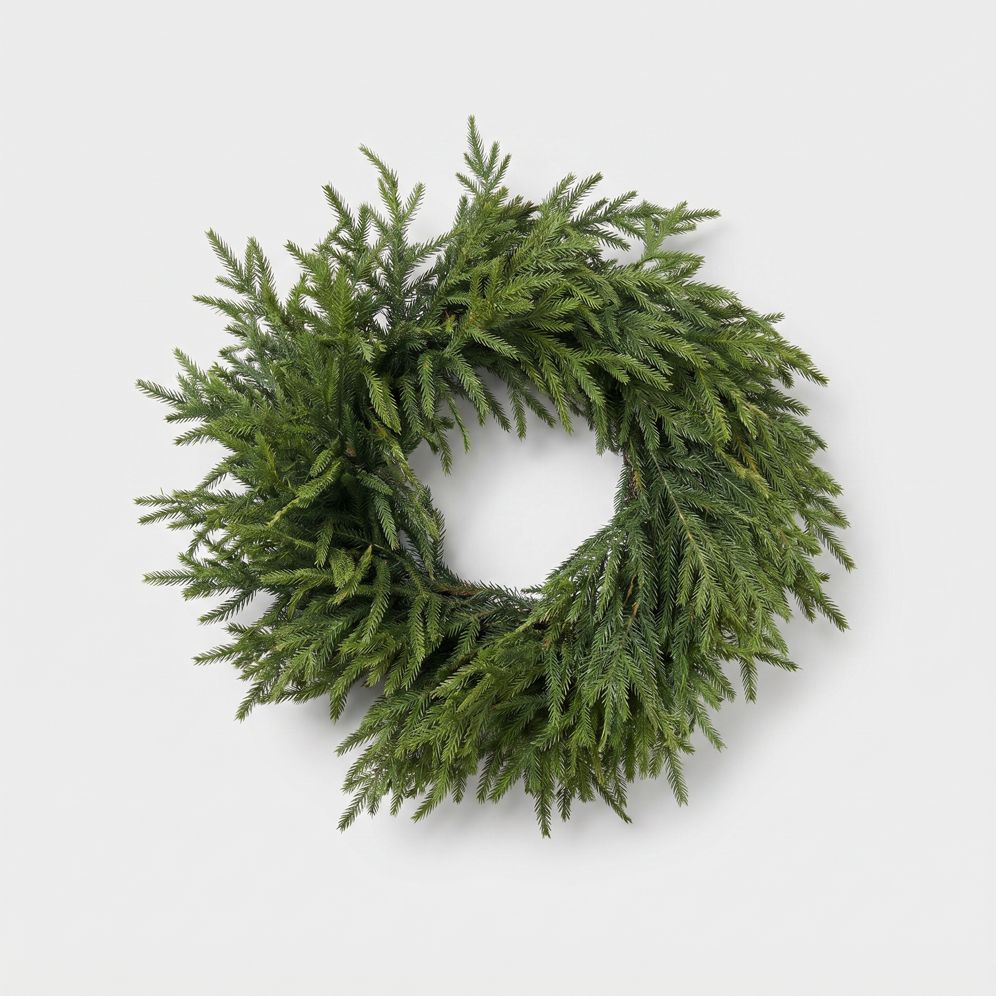 24-inch Norfolk pine wreath with lush lifelike green needles on a clean off-white background