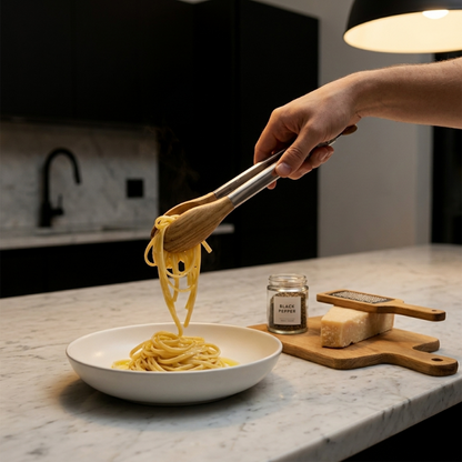 Stainless steel and wood tongs serving sauce in ceramic bowl