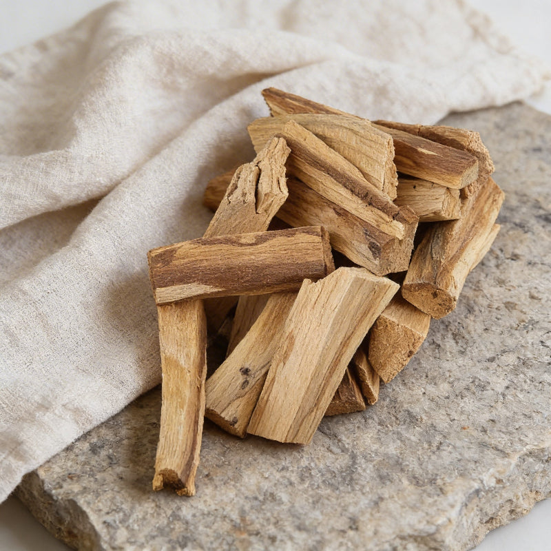 Wooden sticks on a stone surface with a beige cloth in the background
