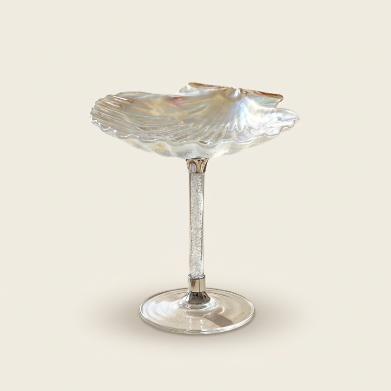 Decorative glass dish with shell design on a white background