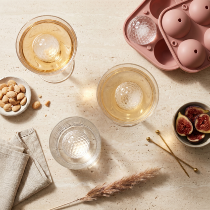 Golf ball ice mold tray with drinks and snacks on table