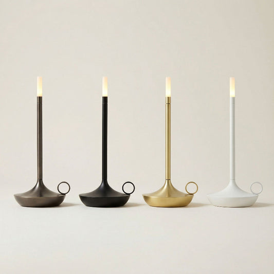 Four candle holders with lit candles on a neutral background