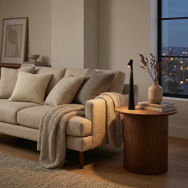 Cozy living room with beige sofa, wooden side table, and decorative items.