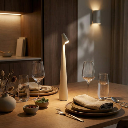 Modern table lamp on a dining table with glasses and plates