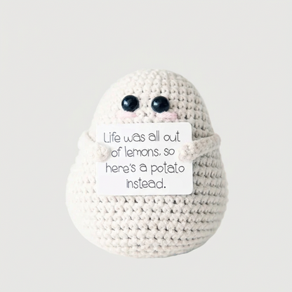 White positive potato crochet doll with handwritten encouragement sign
