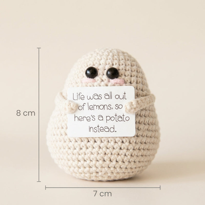 Crocheted potato with a humorous message and measurements on a beige background